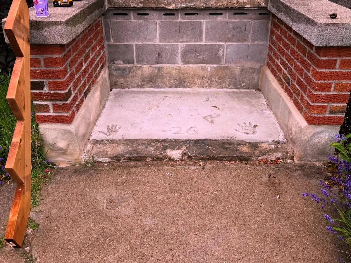 New concrete landing at a brick porch.